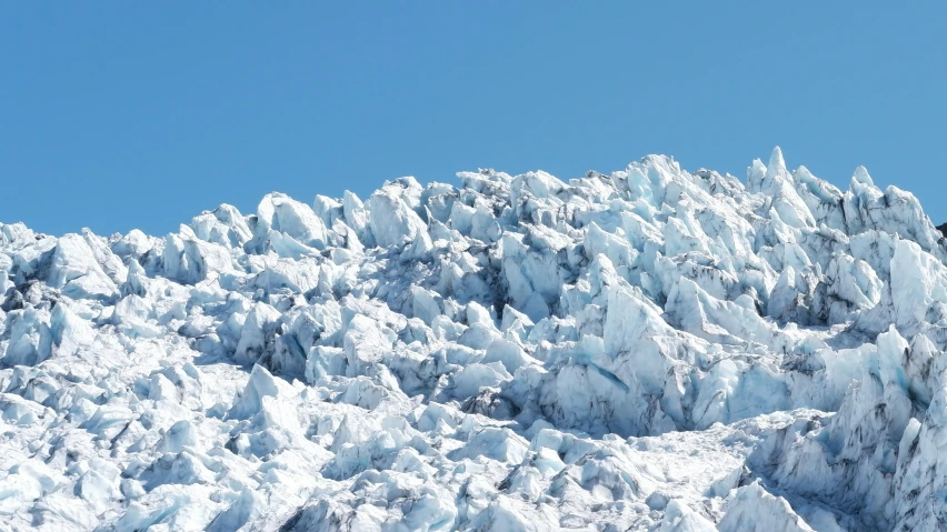 snow covered rock outcropping with skiers on skis