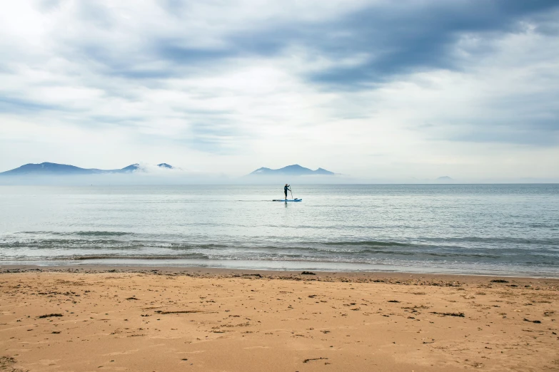 a small wave is moving along the sandy beach