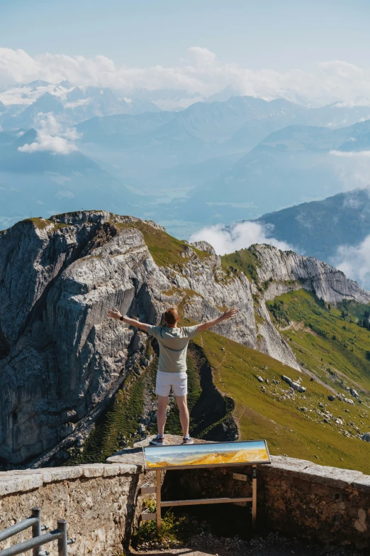 man on top of the rock and standing on a small wooden table