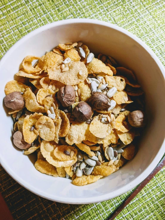 a bowl of mixed nuts and snacks with an open spoon