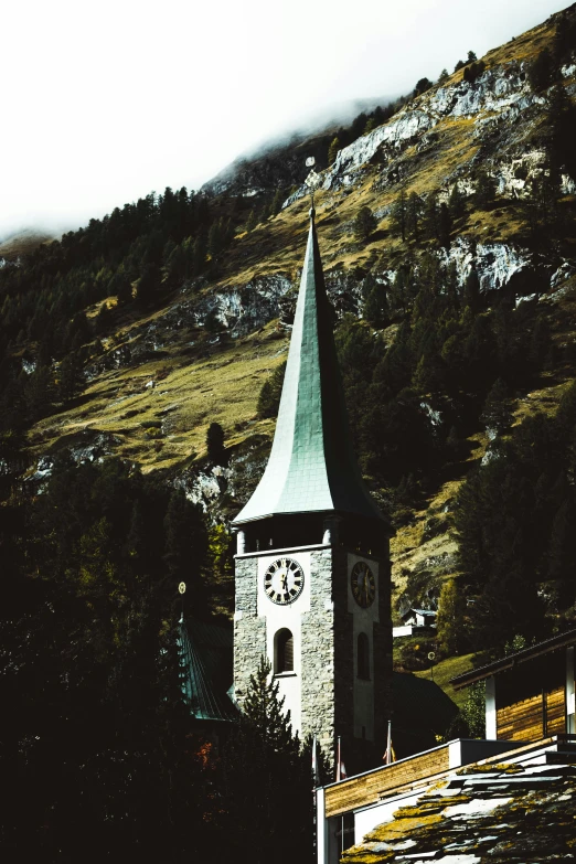 a tower with a clock on it in the middle of a mountain