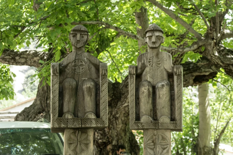 two statues with the faces of two men in suits