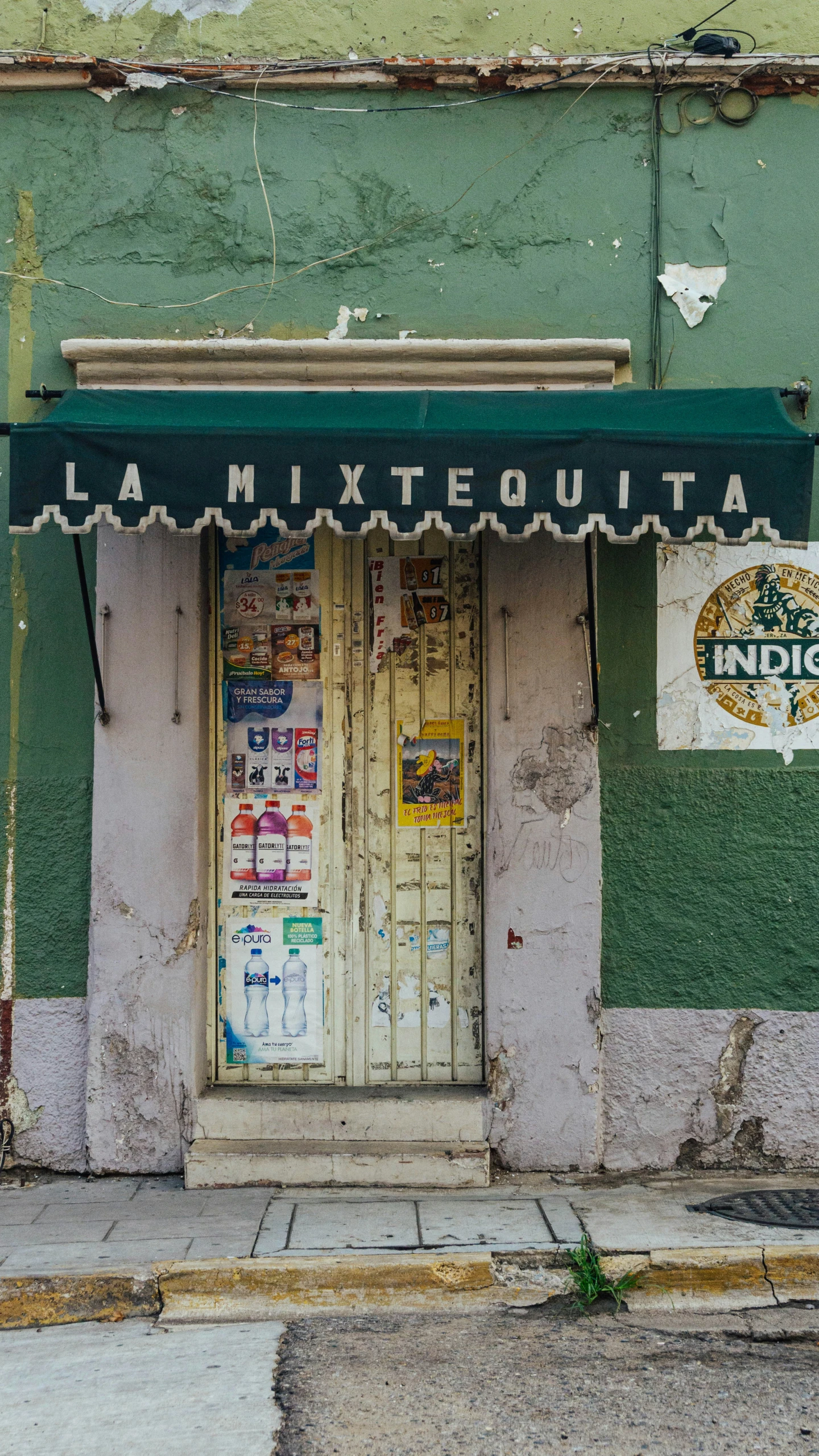 an old building with a doorway and several advertit on it