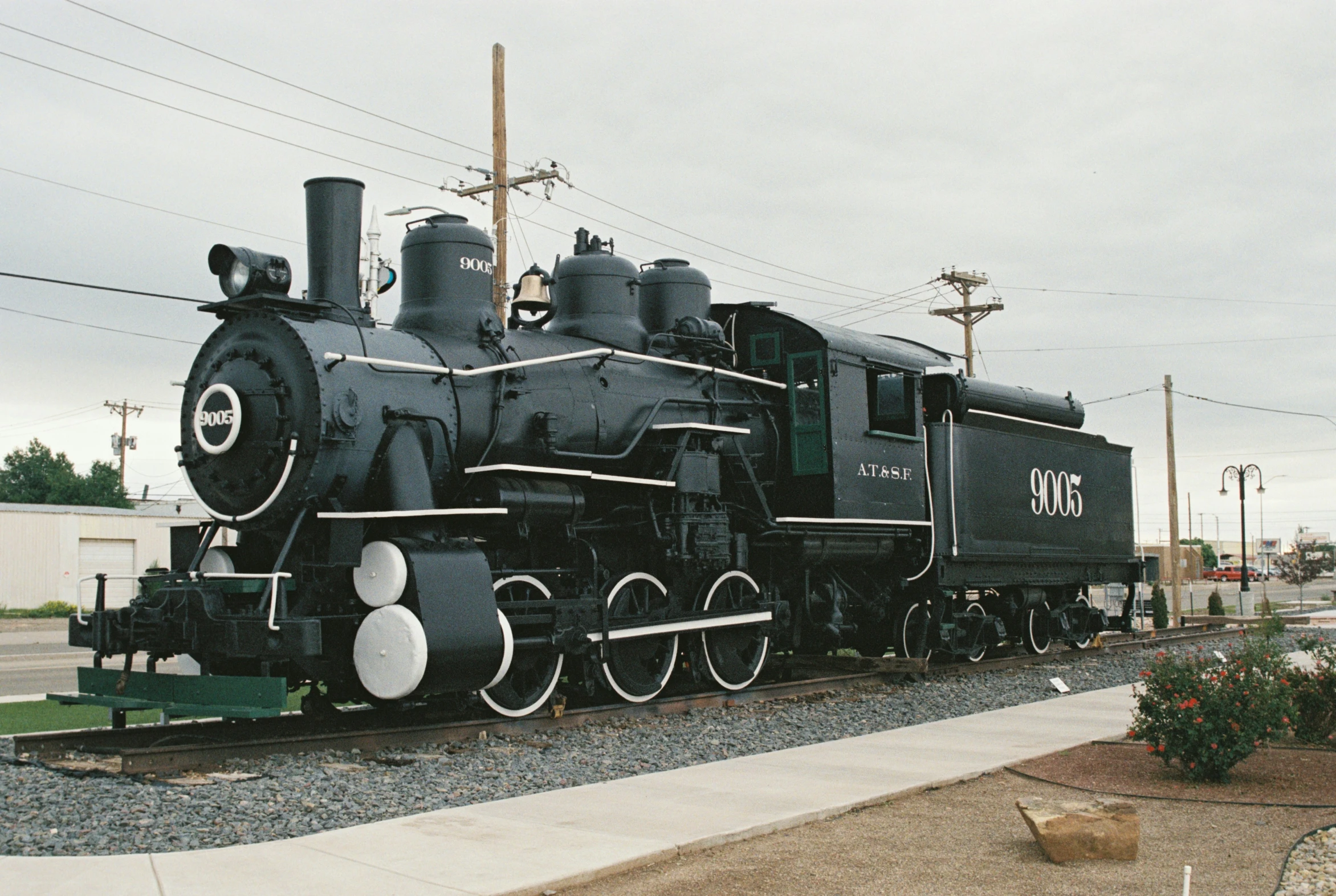 a black train is parked on some railroad tracks