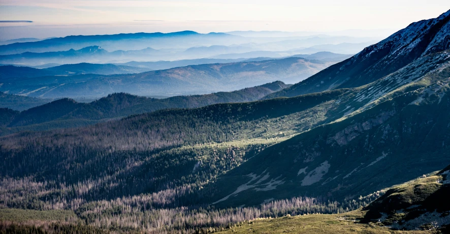 a mountain is shown with mountains and woods in the distance