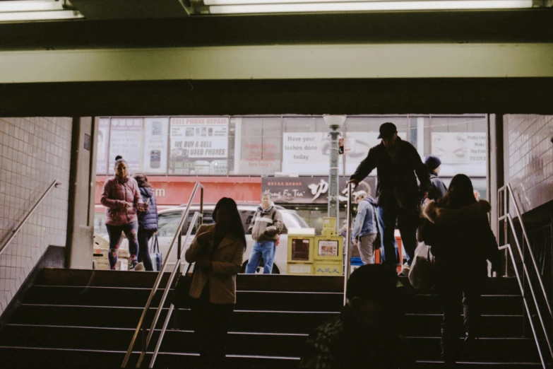 a group of people standing around a stairway near a window