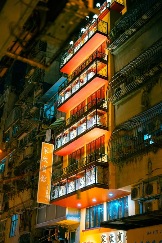 a tall building has many balconies that are lit