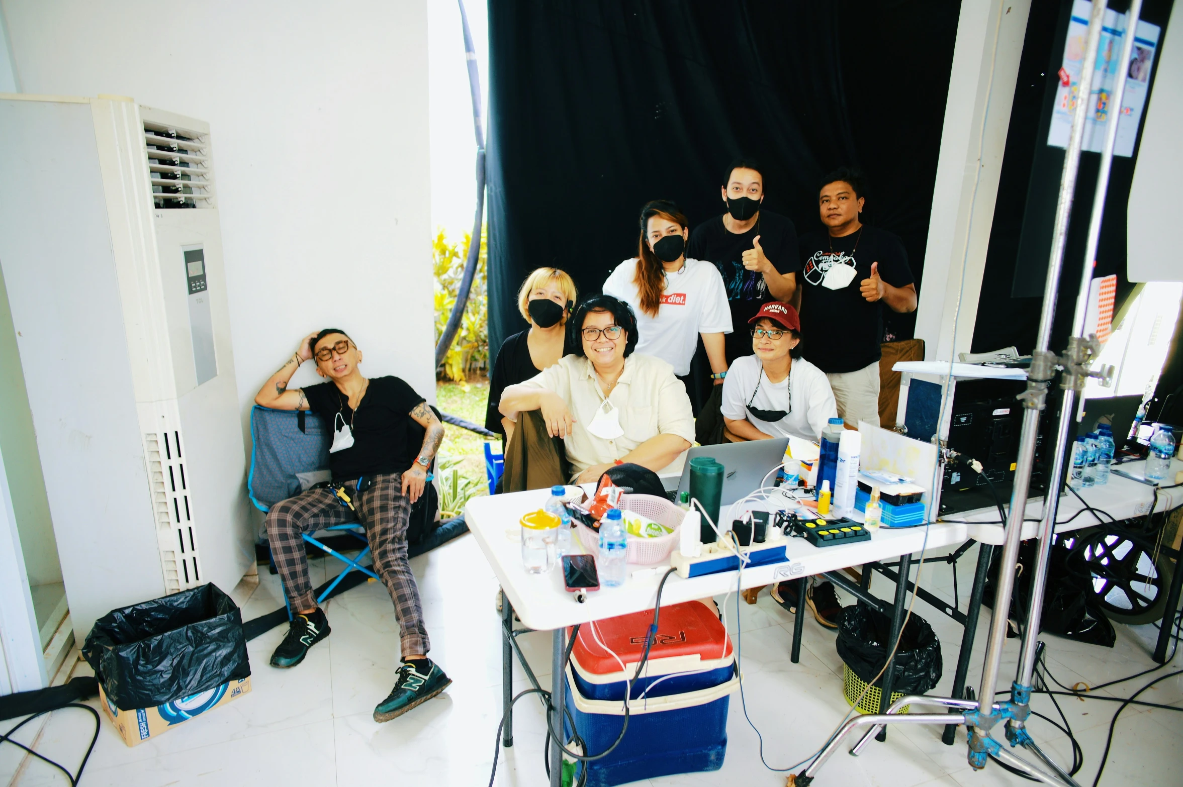 people stand and sit in front of a camera in a po studio