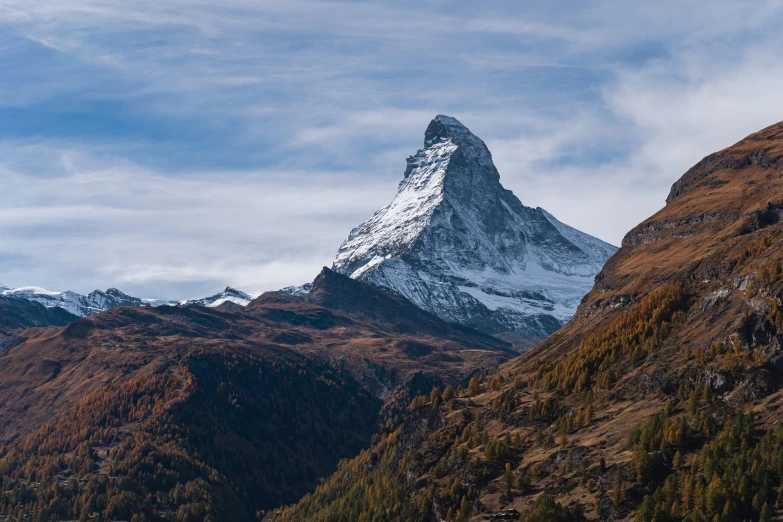 mountains with a snow covered peak and blue skies