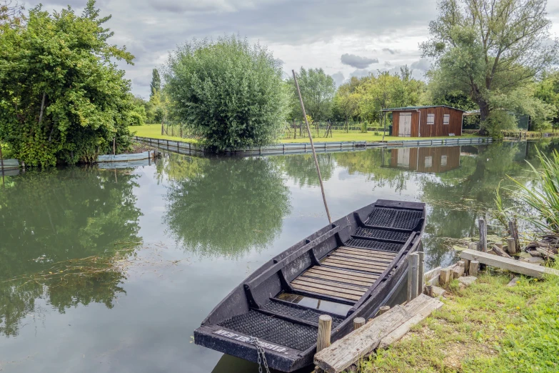 a row boat is docked near the shore