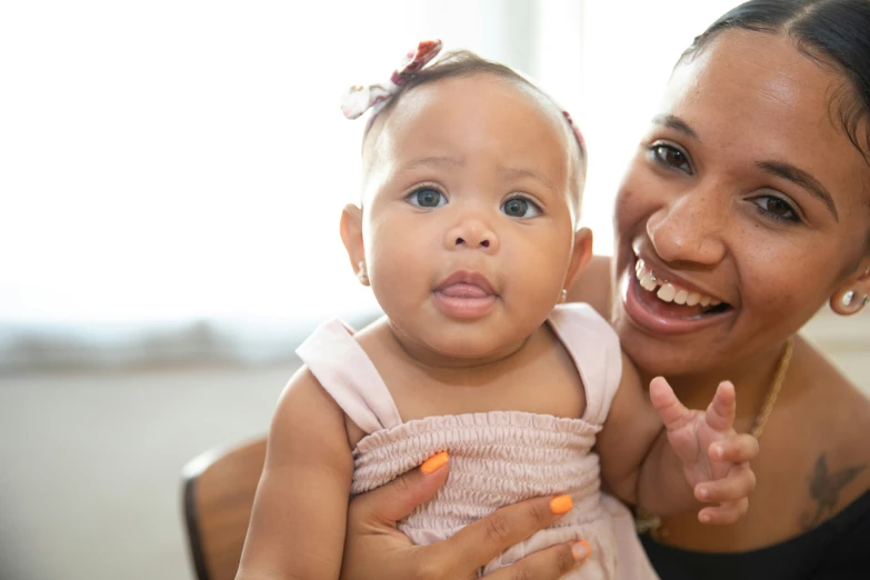 the mother is holding the baby girl and pointing her finger