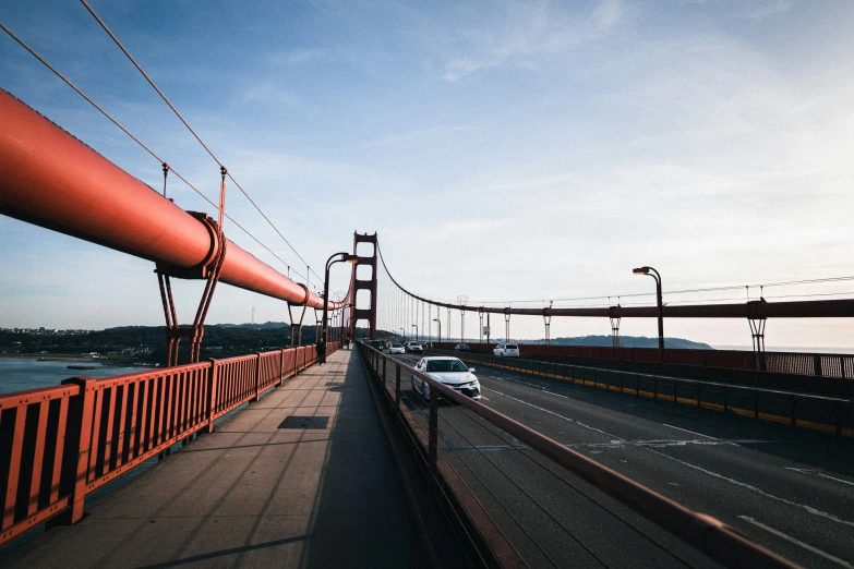 two cars driving along a bridge while others pass by