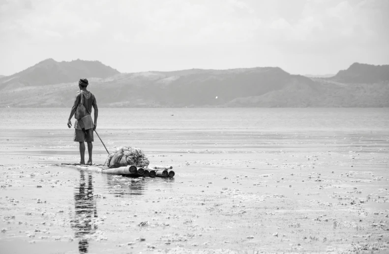 a man walking along a body of water with a dog