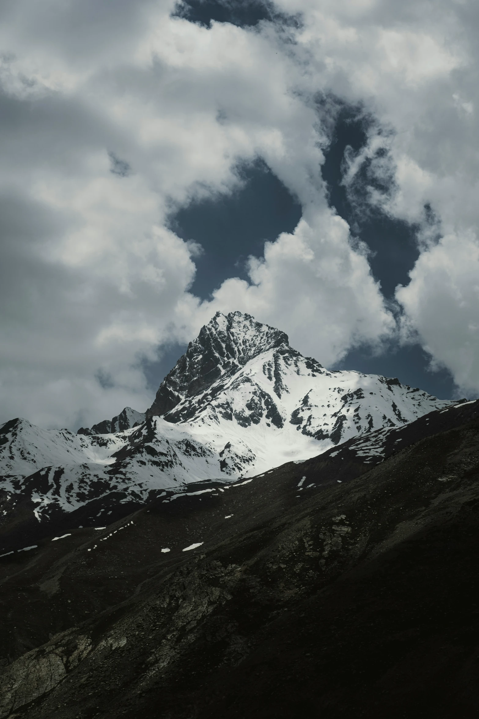 a cloudy day at the peak of a snowy mountain