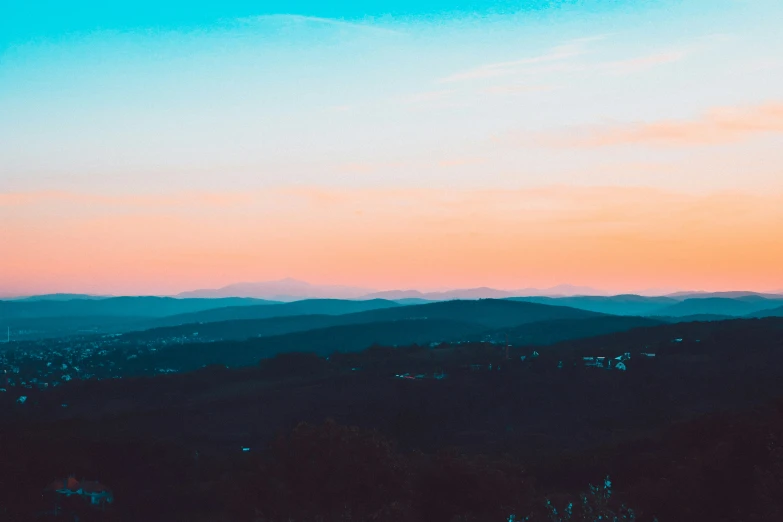 the sky is pink and blue above the trees