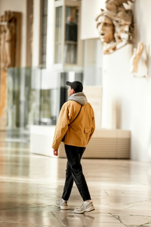 a man is walking through a building near a sculpture