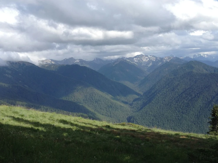 a scenic view from the summit of a hill to some very tall mountains