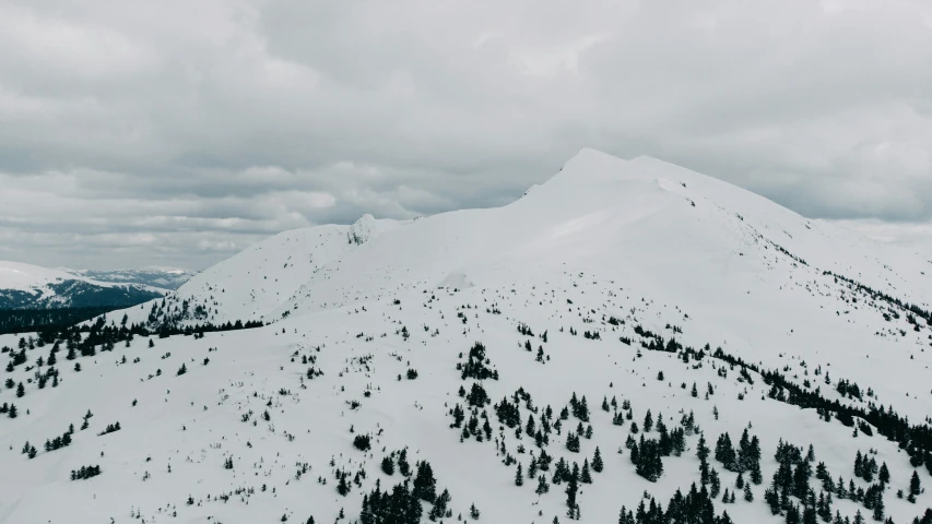 two people on skis walking up a snow covered hill