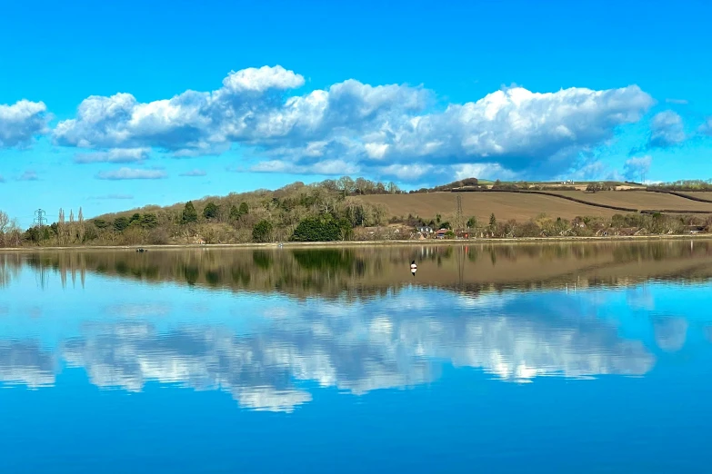 an empty lake and mountains with clouds in the sky