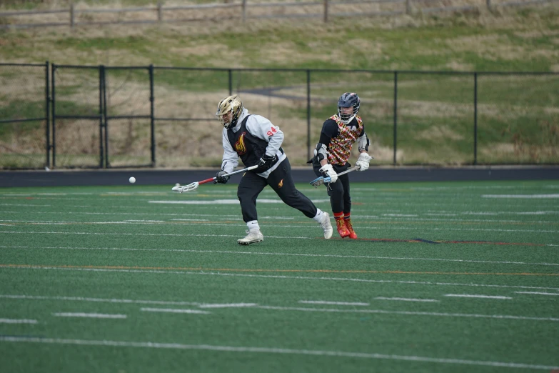 two people playing field hockey on an astroturt