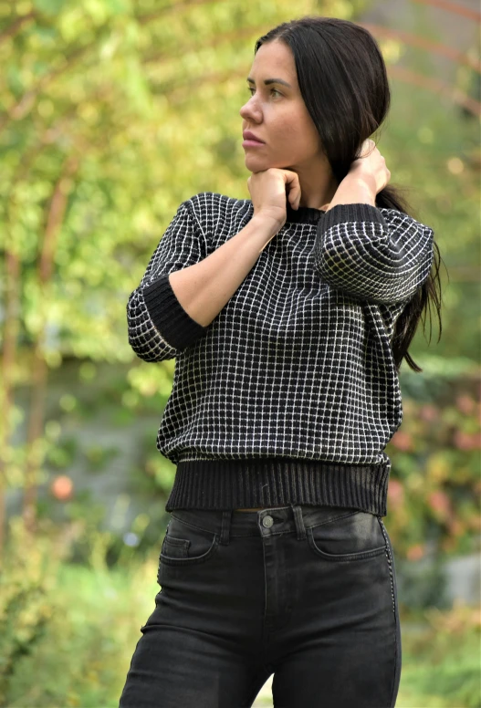 a woman in jeans and sweater posing for the camera