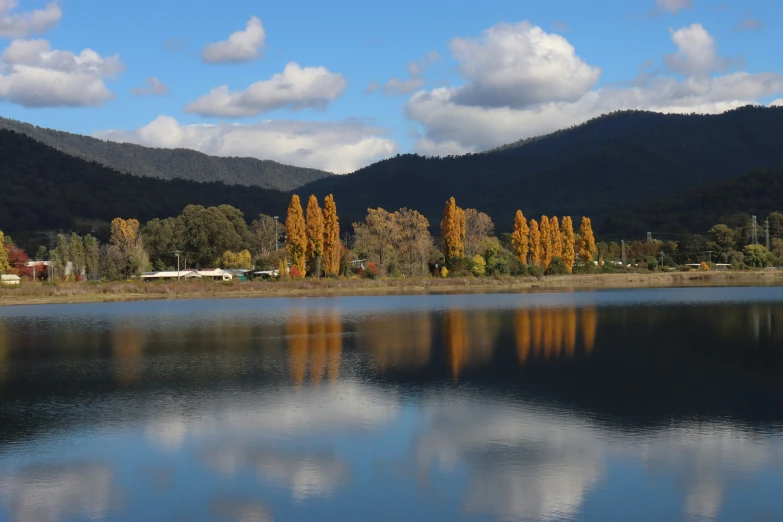 a lake near mountains is reflecting the sky