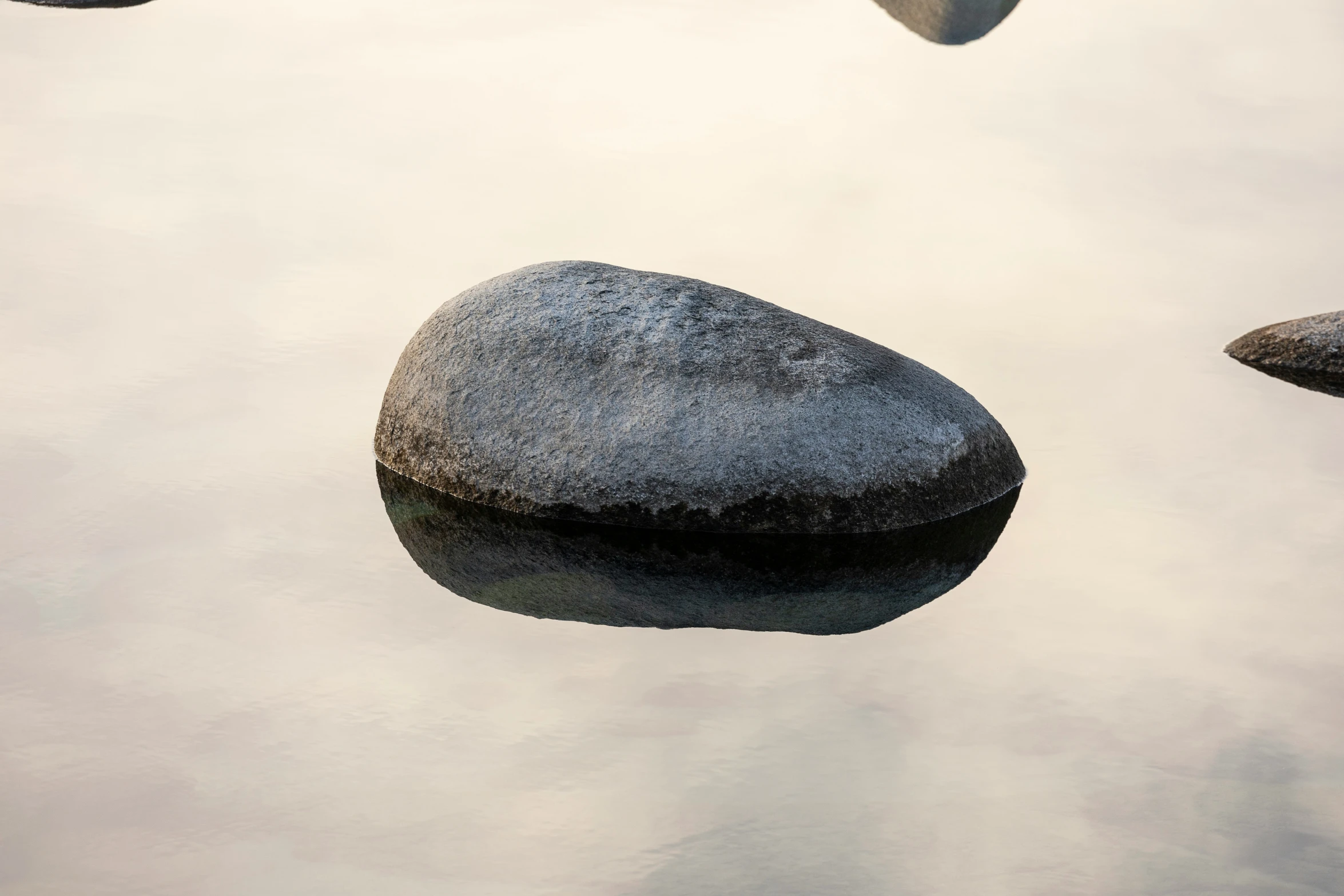 there are two rocks on the water with sky in background