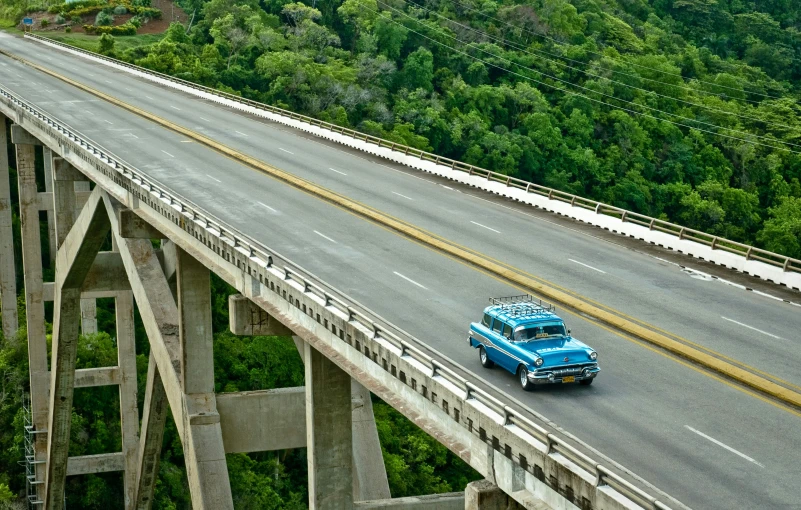 an old truck drives across a bridge on a clear day