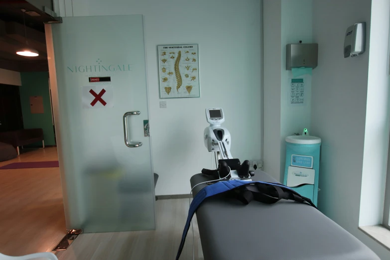 a hospital room door is opened to reveal a bed with a blue cover