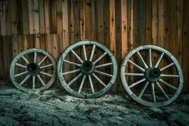 two different kinds of wheels next to wooden wall