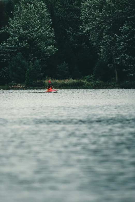 a person in a small boat out on the lake