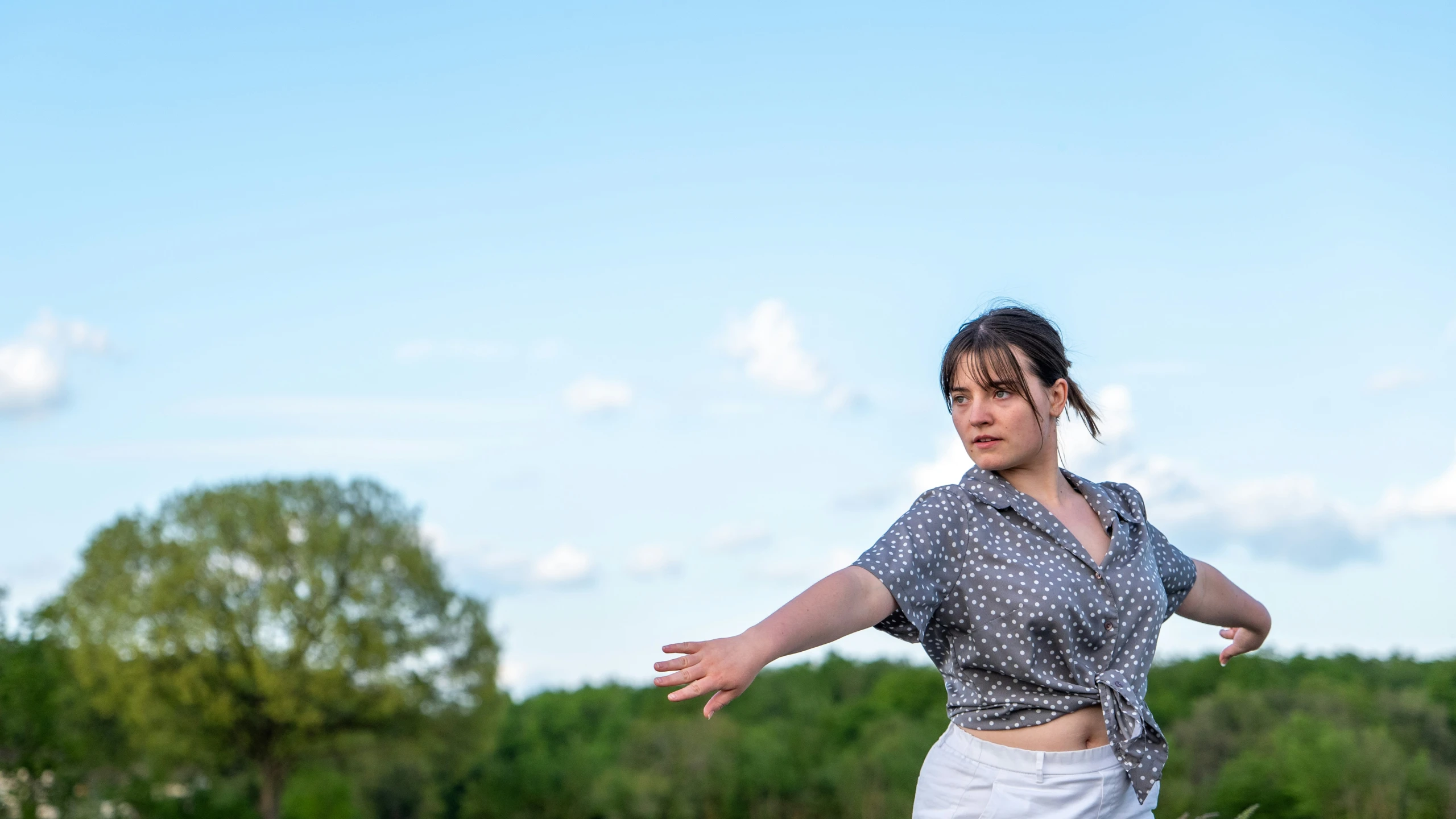 a woman with her arms out ready to throw a frisbee