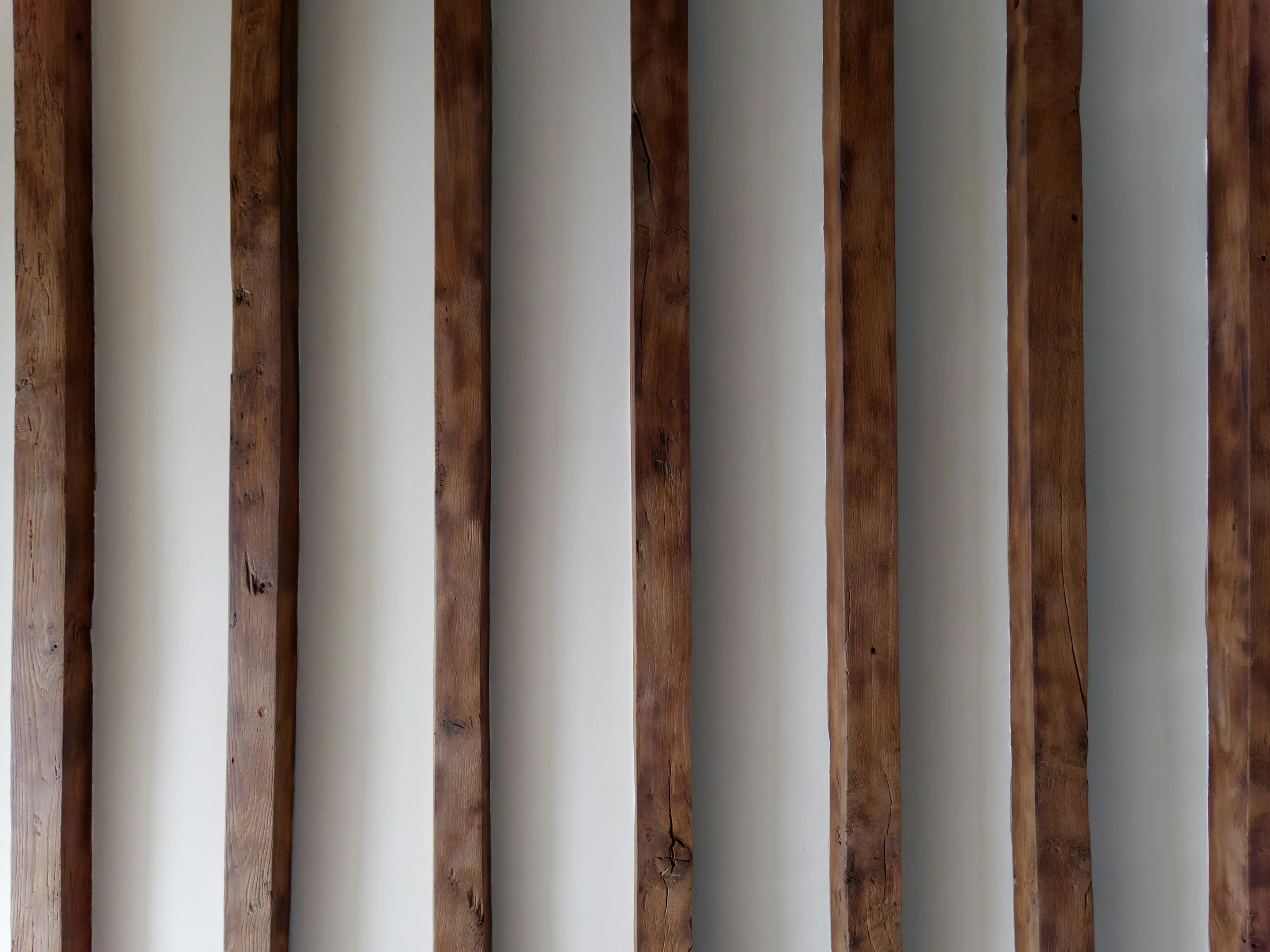 several long thin wood beams stand in a row