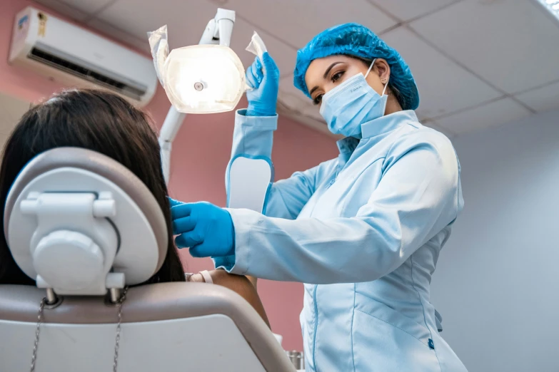 the woman wearing a mask and gloves is being examined