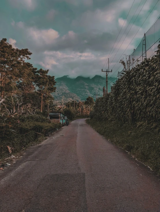 a long and narrow road on a cloudy day