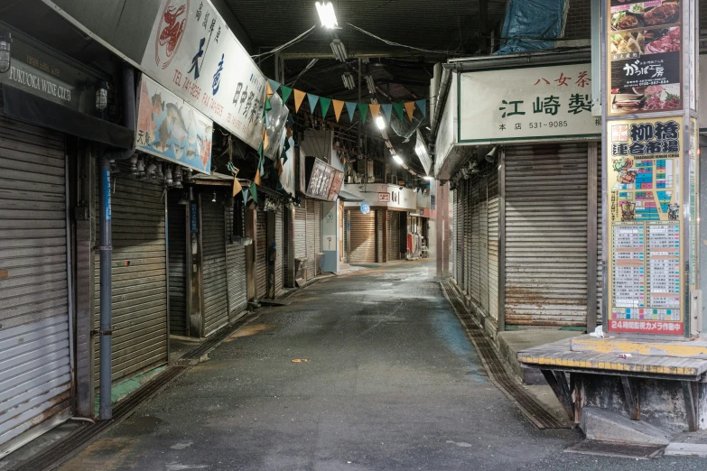 an alley with several closed doors and banners