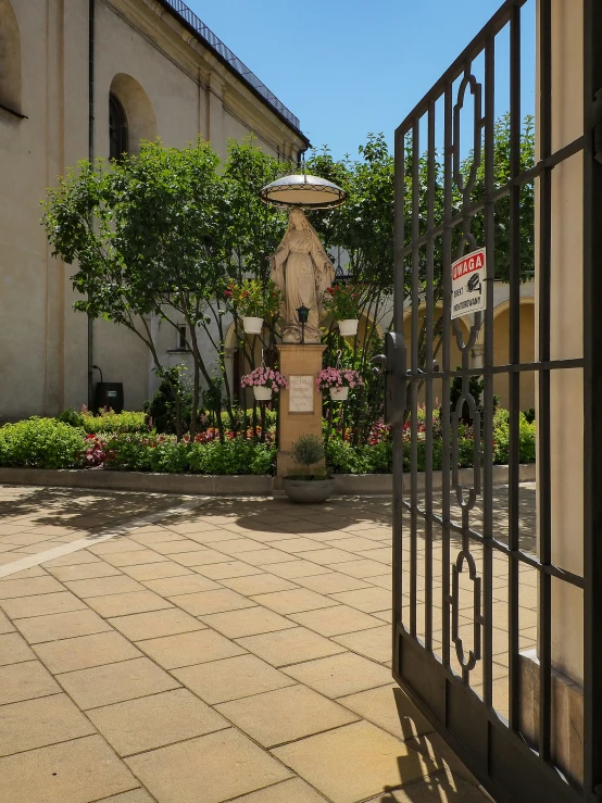 a courtyard with a tree and bushes and a fountain