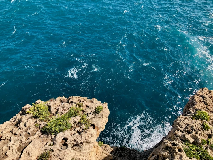 the view of a boat in the ocean from a cliff