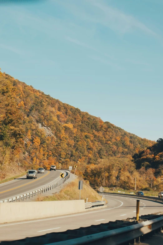 a highway with vehicles traveling on it and hills in the background