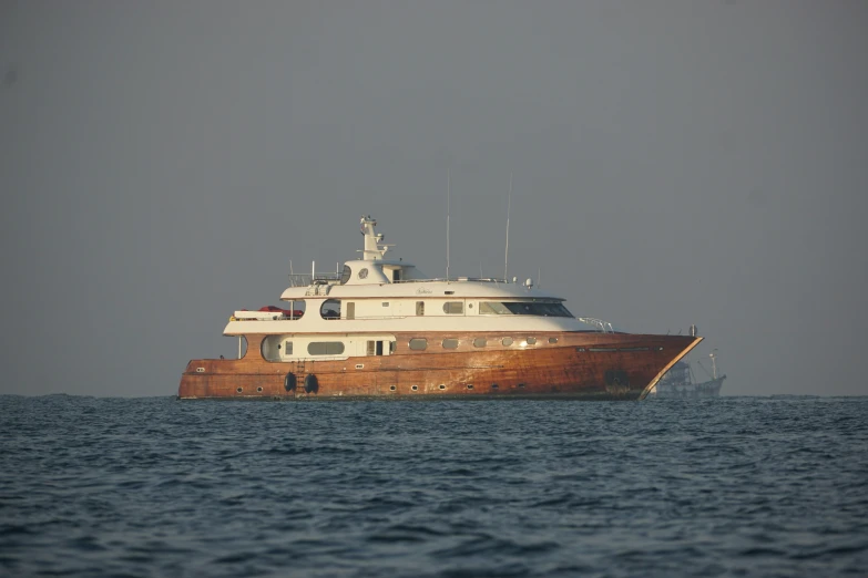 the brown and white boat is moving along the water