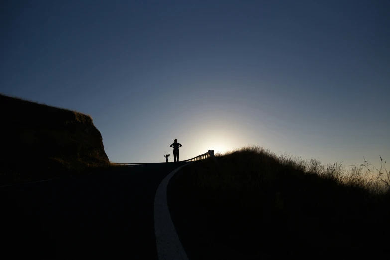 a man is standing on the edge of a hill