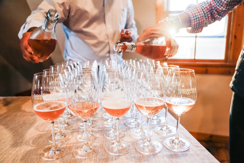 a group of people at a party standing around drinking some wine