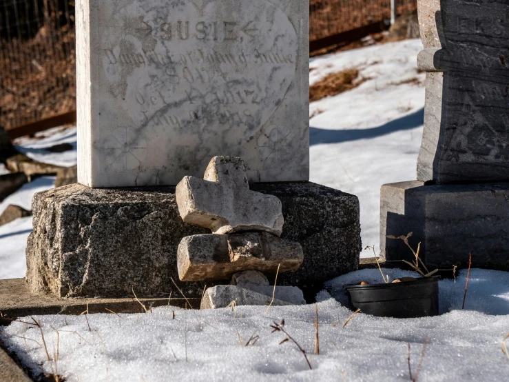 some snow and rocks next to a grave