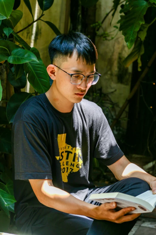 a  wearing glasses and reading a book