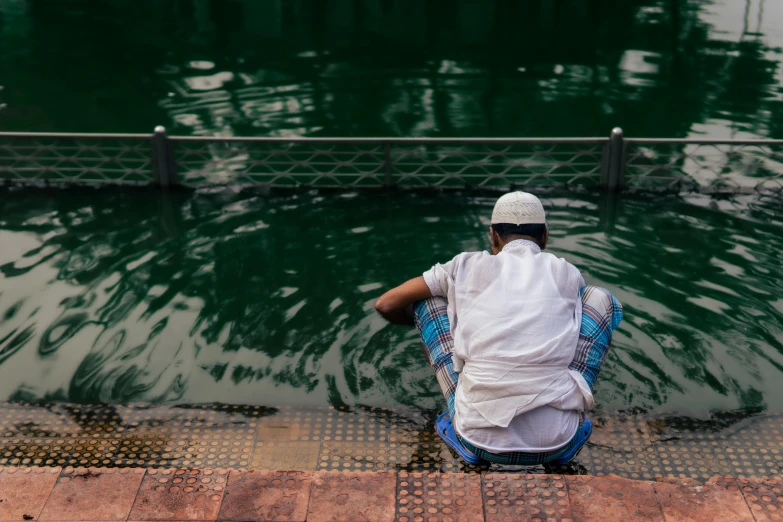 the man sits in the middle of the pond