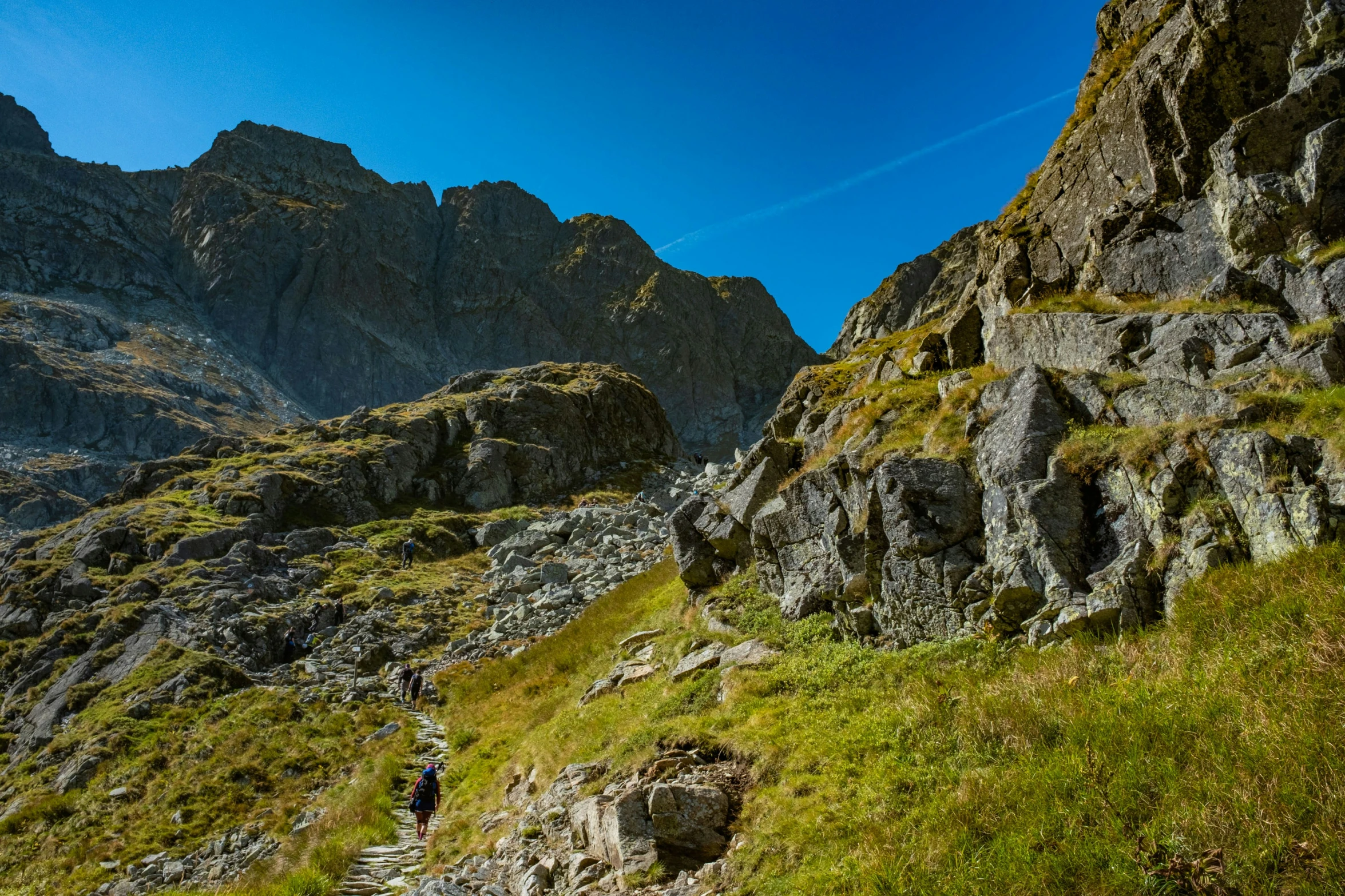 the two hikers have stopped to reach the high edge of the cliff