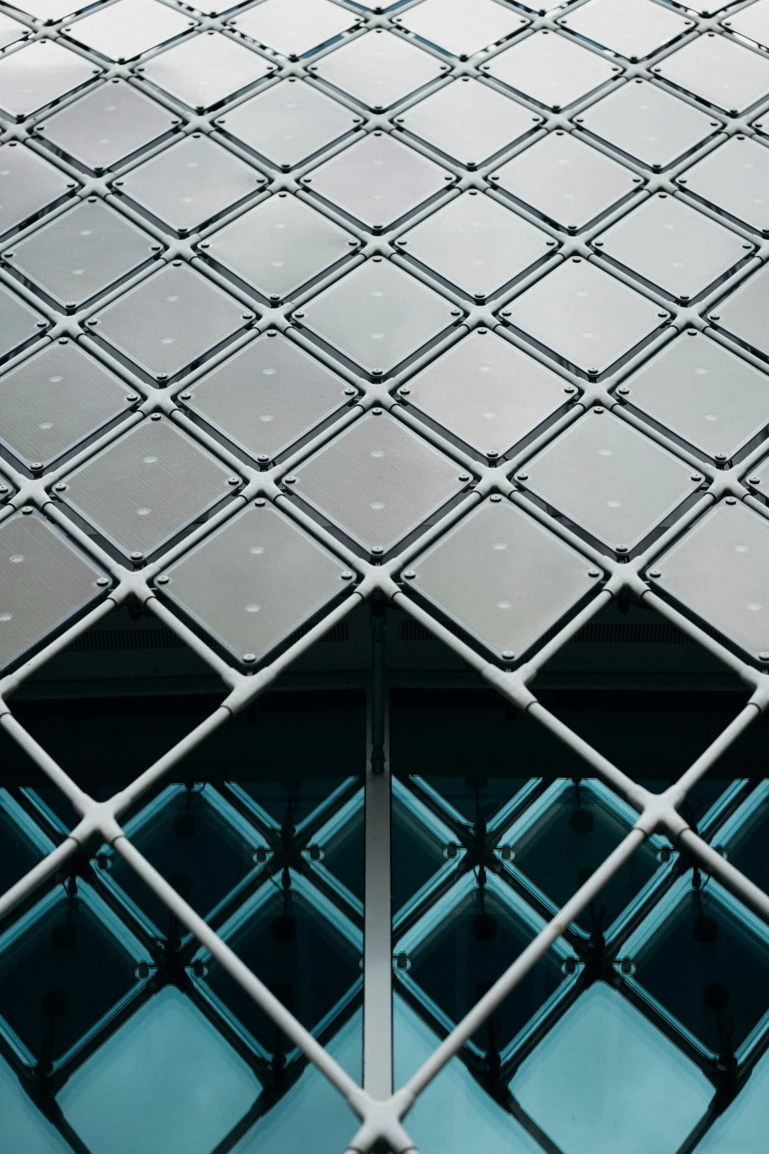 an abstract metal diamond shaped building with blue glass