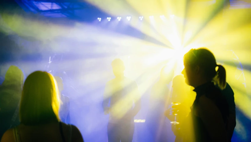 people at a party with colored lights streaming in