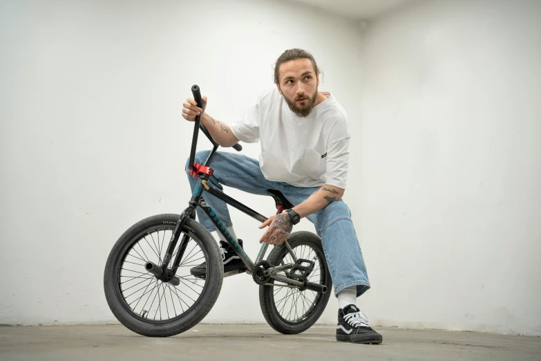 a man sitting on top of a bike posing for the camera