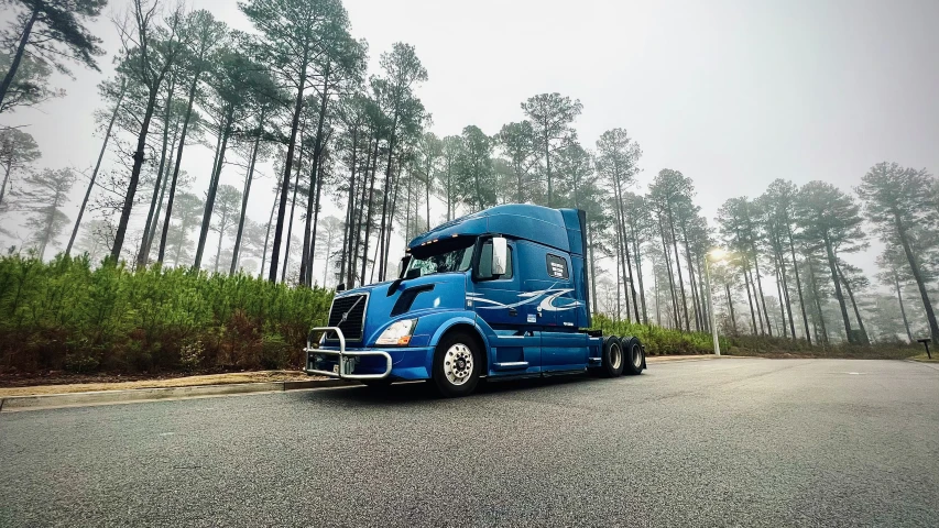 a blue semi truck drives down the street